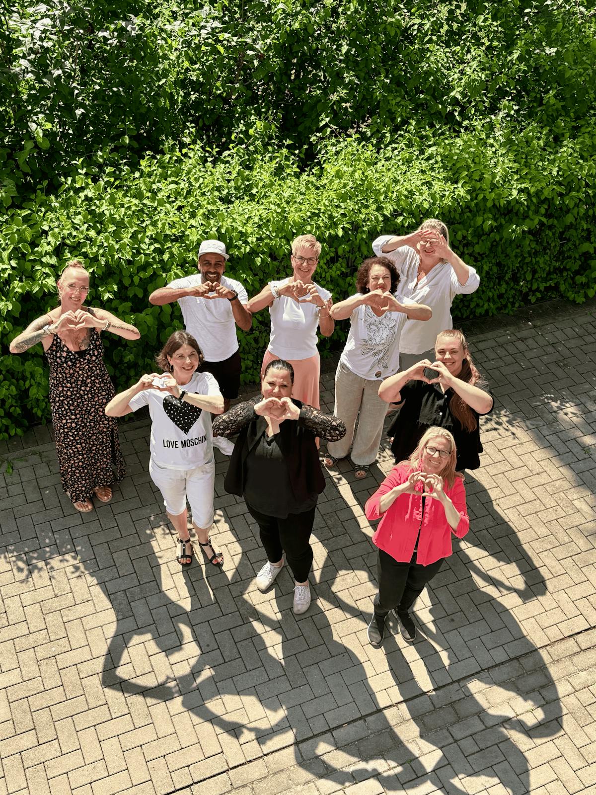 Das ARCHIMED-Team der Schul- und Kitabegleitung formt Herzen mit den Händen