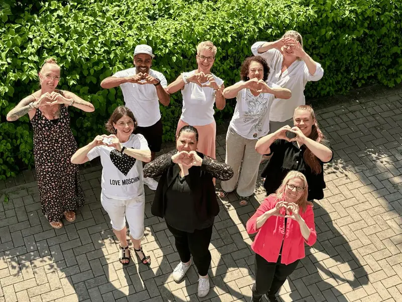 Das ARCHIMED-Team der Schul- und Kitabegleitung formt Herzen mit den Händen